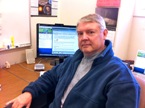 Caltechs James Kent Blackburn sits at his desk with the Duet PCS speakerphone system behind him.